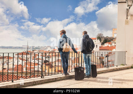 Vom 7. März 2018: Lissabon, Portugal - Zwei junge Männer mit Übertrag auf Gepäck, wenn man die Aussicht auf die Stadt von der Miradouro de Santa Estevao. Stockfoto