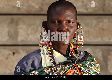 Alte Masai Dame mit traditioneller Kleidung und Masai Ohrringe auf Masai Ohr portrait Stockfoto