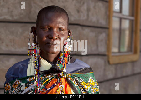 Alte Masai Dame mit traditioneller Kleidung und Masai Ohrringe auf Masai Ohr portrait Stockfoto