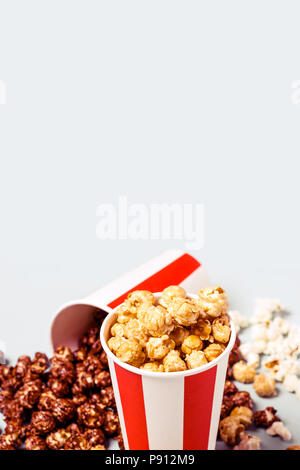 Sortiert Popcorn in Papier set striped weiß rot Tasse. Süßes und salziges Popcorn. Stockfoto