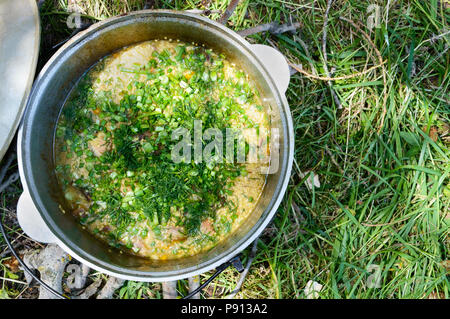 Lecker brei Couscous mit Fleisch, Gemüse und frische Kräuter in einem Topf kochen auf die Natur. Die Ansicht von oben Stockfoto