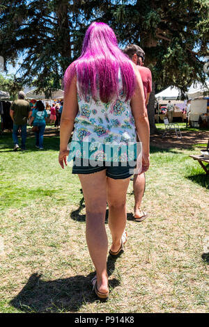 Frau mit langen lila Haare walking im Park; Salida, Colorado, USA Stockfoto