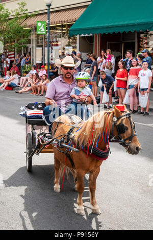 Vater & Baby in Miniatur von Pferden gezogene Wagen; jährliche Viertel der Juli Parade in der kleinen Bergstadt Salida, Colorado, USA Stockfoto