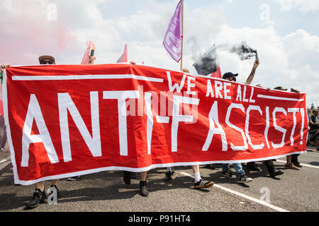 London, Großbritannien. 14. Juli 2018. Antifaschisten halten Rauch Granaten wie Sie März über die Westminster Bridge der rechtsextremen "Freien Tommy' (Robinson) und Trump Anhänger '' Willkommen Märsche Trump' zu erheben. Es gab einige Auseinandersetzungen, wie die anti-faschistischen März wurde von Freien Tommy Anhänger am Rande des Parliament Square angegriffen. Credit: Mark Kerrison/Alamy leben Nachrichten Stockfoto