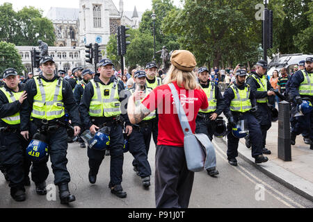 London, Großbritannien. 14. Juli 2018. Die Metropolitan Police Officers bewegen eine antifaschistische weg vom freien Tommy Verfechter, die angegriffen hatte eine antifaschistische März durch London in Opposition zu den Rechtsextremen "Freien Tommy' (Robinson) März am Rande des Parliament Square. Credit: Mark Kerrison/Alamy leben Nachrichten Stockfoto