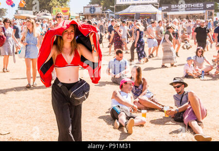 Portrait von Festival goer, die Jacke über den Kopf, um sich von der starken Sonne zu schützen, auf Latitude Festival, henham Park, Suffolk, England, 14. Juli 2018 Stockfoto