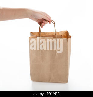 Braune Papiertüte auf weißem Hintergrund. aus nächster Nähe erschossen Stockfoto