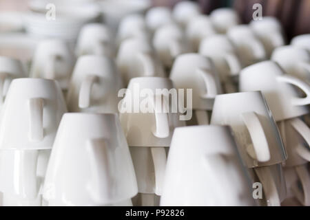 Viele Zeilen aus reinem weißen Kaffeetassen auf weißen Tisch Stockfoto