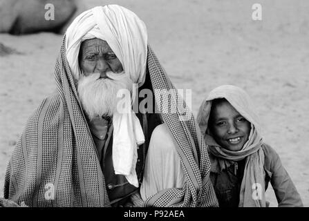 RAJASTHANI KAMEL HÄNDLER mit seinem Enkel im PUSHKAR CAMEL FAIR - Rajasthan, Indien Stockfoto