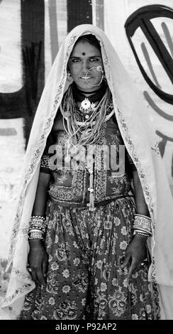 Porträt einer BANJARI FRAU mit einem goldenen Ring in tribal Kleidung am PUSHKAR CAMEL FAIR - Rajasthan, Indien Stockfoto