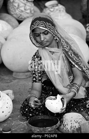 Rajasthani Frau malt einen Ton-Topf für das GANGUR FESTIVAL in JOHDPUR - RAJASTHAN, Indien Stockfoto