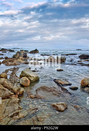 Ruhige Küste mit unregelmäßig geformten Felsen, Sanya, Hainan Island, China Stockfoto