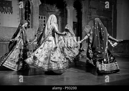 Rajasthani Frauen führen Sie einen traditionellen Tanz in ihren bunten seidenkleider am BAGORE KI HAVELI in Udaipur, Rajasthan, Indien Stockfoto