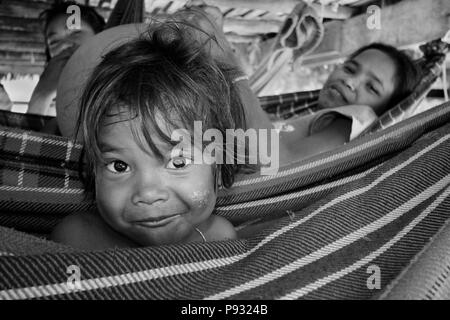 Moken (Sea Gypsy) Kind Schaukeln in der Hängematte in seinem Dorf auf Ko Surin thailändischen Insel in Mu Ko Surin Nationalpark - ANDAMAN SEA, THAILAND Stockfoto