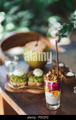 Gesund leckeres Frühstück - chia Milchreis mit frischen Früchten, Müsli und Avocado auf Toast Stockfoto