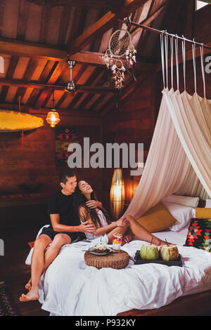 Junges Paar in Liebe, Frühstück im Bett, in der traditionellen indischen Holzhaus in Hippie style Stockfoto