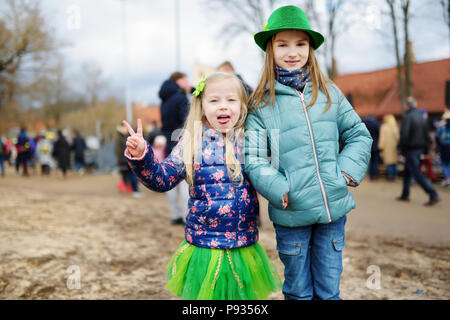 Zwei süße kleine Mädchen tragen grüne Hüte und Accessoires feiern St. Patrick's Day in Vilnius. Kinder Spaß an der traditionellen irischen Festival. Stockfoto