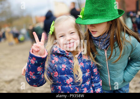 Zwei süße kleine Mädchen tragen grüne Hüte und Accessoires feiern St. Patrick's Day in Vilnius. Kinder Spaß an der traditionellen irischen Festival. Stockfoto