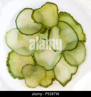 Dünne Scheiben Gurke auf einem weißen Teller. Stockfoto