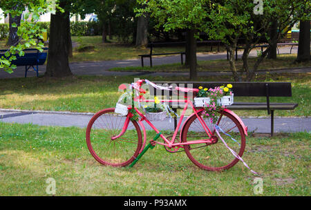 Rosa Fahrrad als dekorativen Blumentopf und Bank im Park Stockfoto