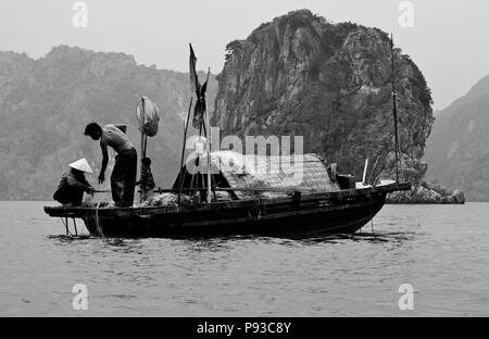 Fischer bei der Arbeit im Wasser der Halong Bay - VIETNAM Stockfoto
