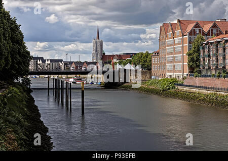 Bremen, Deutschland - Red Brick waterfront Gebäude und große Brücke über die Weser mit Kirchturm in der Ferne Stockfoto