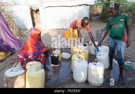 Kakuma, Kenia - Im Flüchtlingslager Kakuma, Flüchtlinge, gießen Sie Wasser in Kanistern an einer Tankstelle. Stockfoto