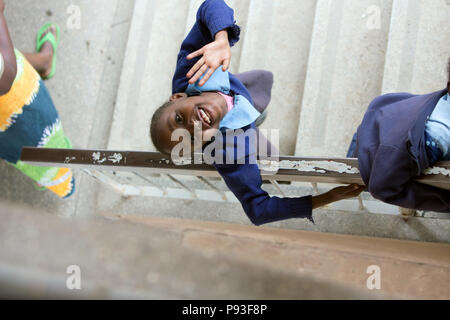 Nairobi, Kenia - Schuluniform Student steht im Treppenhaus des St. John's Community Centre Pumwani auf den Betrachter. Stockfoto