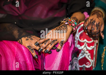 Schwarzes Henna Hands Zeichnungen auf Frauen für afrikanische Hochzeitsfeier mit großen Ringen Stockfoto