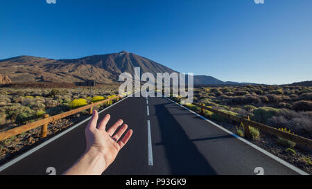 Gerade asphaltierte Straße mit Hand, die auf die Spitze des Pico del Teide Vulkan einladen. Nationalpark Teide, Teneriffa, Kanarische Inseln, Spanien. Stockfoto