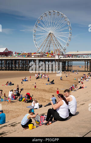 Großbritannien, England, Lancashire, Blackpool, Besucher Entspannen im Sonnenschein auf Sea Wall Schritte durch Central Pier Stockfoto