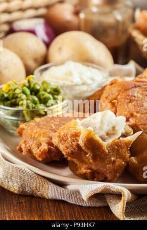 Traditionelle Fisch im Bierteig und Chips mit Erbsen und Sauce Tartar Stockfoto