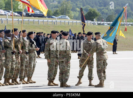 Oberst Curtis A. Bussard, ausgehende Befehlshaber des Joint Multinational Readiness Center, übergibt die Guidon, JMRC, Kommandant der 7. Armee den Befehl, Brig. Gen. Christopher C. LaNeve, an JMRC des Befehls Zeremonie am Hohenfels, Hohenfels, Deutschland, 10. Juli 2018. Die Änderung des Befehls Zeremonie ist eine Tradition, die eine formelle Übertragung der Autorität und Verantwortung des scheidenden Kommandanten an die eingehenden Commander. (U.S. Armee Foto von SPC. Randy Wren) Stockfoto