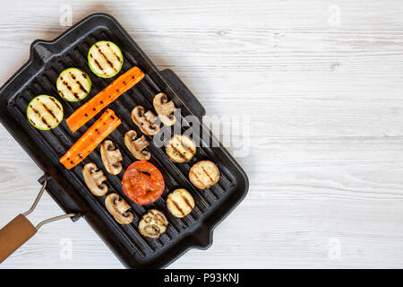 Gegrilltes Gemüse in einer Pfanne Grillen auf einem weißen Holz- Hintergrund, Ansicht von oben. Kopieren Sie Raum und Text. Stockfoto