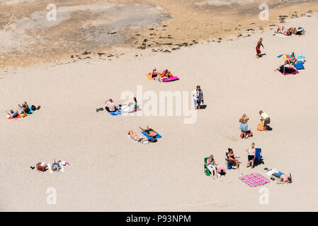 Urlauber Entspannen und Sonnenbaden auf den Towan Strand in Newquay in Cornwall. Stockfoto