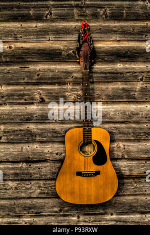 Acoutic Guitar, Cowboy-Hut, Cowboy-Stiefel und alte, Alter Bauernhof Schuppen Wand. Ländlichen Alberta, Kanada. Stockfoto