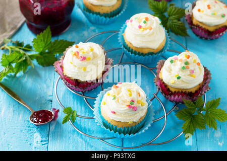 Geburtstag Cupcake mit buttercream Vereisung und Himbeermarmelade auf einem Holztisch. Stockfoto