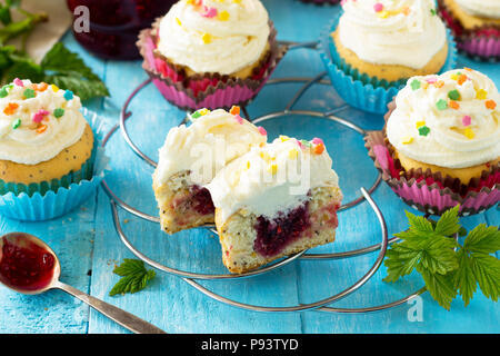Bunte orange Cupcake Geburtstag mit himbeermarmelade Close-up auf einem Holztisch. Stockfoto