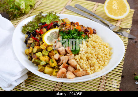 Köstliche orientalische Salat tabbouleh. Couscous mit gebratenem Gemüse und Huhn auf einem weißen Teller. Traditionelle libanesische Vorspeisen. Stockfoto