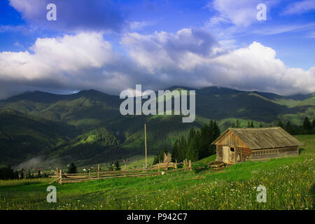 Foto von Bergdorf im Sommer unter schönen bewölkten Himmel. Ukraine, Karpaten, Dzembronia. Stockfoto