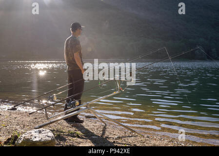 Angeln Adventures, Karpfen angeln. Angler am Ufer eines Sees Stockfoto