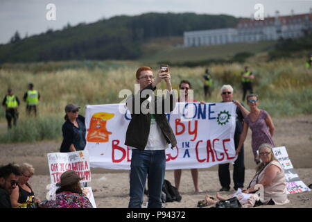 Grüne MSP Ross Greer nimmt eine selfie mit Demonstranten auf dem Strand in der Nähe des Trump Turnberry Resort in South Ayrshire, wo US-Präsident Donald Trump und First Lady Melania Trump das Wochenende verbringen. Stockfoto