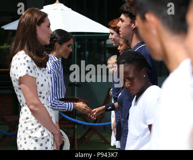 Die Herzogin von Cambridge (links) und die Herzogin von Sussex treffen ball Jungen und Mädchen, die während eines Besuchs auf der Wimbledon Championships in der All England Lawn Tennis und Croquet Club, Wimbledon. Stockfoto