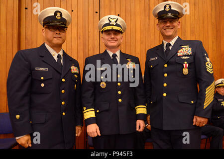 Coast Guard 13. Bezirk Master Petty Officer Jason Wong, auf-kommenden command Master Chief, hintere Adm. David Throop, Commander, und der Master Chief Petty Officer Sean McPhilamy, die Ausrückenden command Master Chief, nehmen Sie an von Change-of-watch Zeremonie in Seattle, 9. Juli 2018 statt. Während der Zeremonie Throop Vorsitz über Wong's Relief von McPhillamy. U.S. Coast Guard Foto von Petty Officer 3. Klasse Amanda Norcross. Stockfoto