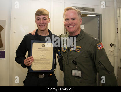 NORFOLK, Virginia (9. Juli 2018) Hospital Corpsman 3. Klasse Sebastian Abbott, von Caldwell, Idaho, USS Gerald R. Ford's (CVN 78) Medizinische Abteilung zugewiesen, erhält seine Ernennungsurkunde in den Rang eines Petty Officer third Class von Kapitän Richard McCormack, Ford's kommandierender Offizier. Abbott war nach seiner Auswahl für die verdienstvolle Förderung Programm gefördert. (U.S. Marine Foto von Mass Communication Specialist 2. Klasse Kristopher Ruiz) (Dieses Bild hat durch die Unschärfe Abzeichen für Zwecke der Sicherheit geändert wurde) Stockfoto