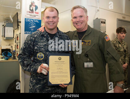 NORFOLK, Virginia (9. Juli 2018) Hospital Corpsman 3. Klasse Joseph Weber, von Waveland, Indiana, USS Gerald R. Ford's (CVN 78) Medizinische Abteilung zugewiesen, erhält seine Ernennungsurkunde in den Rang eines Petty Officer third Class von Kapitän Richard McCormack, Ford's kommandierender Offizier. Weaver war nach seiner Auswahl für die verdienstvolle Förderung Programm gefördert. (U.S. Marine Foto von Mass Communication Specialist 2. Klasse Kristopher Ruiz) (Dieses Bild hat durch die Unschärfe Abzeichen für Zwecke der Sicherheit geändert wurde) Stockfoto