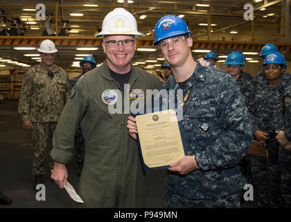 NORFOLK, Virginia (9. Juli 2018) Der Bootsmann Mate 2. Klasse Patrick Fitzgerald, von Washingtonville, New York, zu USS Gerald R. Ford's (CVN 78) deck Abteilung zugewiesen, erhält seine Ernennungsurkunde in den Rang eines Petty Officer Second class von Kapitän Richard McCormack, Ford's kommandierender Offizier. Fitzgerald war nach seiner Auswahl für die verdienstvolle Förderung Programm gefördert. (U.S. Marine Foto von Mass Communication Specialist 2. Klasse Katze Campbell) Stockfoto