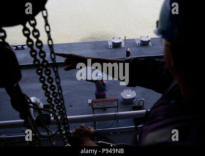 NORFOLK, Virginia (11. Juli 2018) der Luftfahrt Bootsmann Mate (Kraftstoff) Airman Jorge Lopez aus Chula Vista, Kalifornien, nach USS Gerald R. Ford's (CVN 78) Luft Abteilung zugewiesen, Signale an der Luftfahrt Bootsmann Mate (Kraftstoff) 2. Klasse Anthony Pinkas, von Johnstown, Pennsylvania während ein Kraftstoff entlasten. Ford ist derzeit die Werften für post Shake down Verfügbarkeit in Newport News, Virginia. (U.S. Marine Foto von Mass Communication Specialist 2. Klasse Ryan Litzenberger) Stockfoto