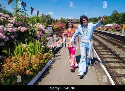 Susanne Lende mit Elvis tribute artist Steve Caprice während der North Yorkshire Moors Railway 60 s Fest 2018 Levisham station in Yorkshire. Stockfoto