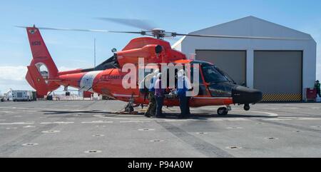 180711-N-NH 199-0072 PAZIFISCHEN OZEAN (11. Juli 2018) Segler zugeordnet zu militärischen Sealift Command Hospital Ship USNS Mercy (T-AH 19), erhalten Sie einen Patienten von einem U.S. Coast Guard MH-65 Dolphin Hubschrauber für die Übertragung zu einer chemischen Dekontamination Zimmer bevor Sie bei Suche und Rettung sowie chemischen Dekontamination Übung zur Unterstützung der Rand des Pazifik (Rimpac), Juli 11. 25 Nationen, 46 Schiffe und fünf U-Boote, über 200 Flugzeuge, und 25.000 Mitarbeiter beteiligen sich an Rimpac vom 27. Juni bis 2. August in und um die hawaiischen Inseln und Südkalifornien. Der Welt Stockfoto